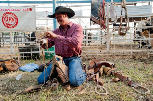 Zaine Seales prepares before his saddle bronc ride at the Shady Dale Rodeo.
